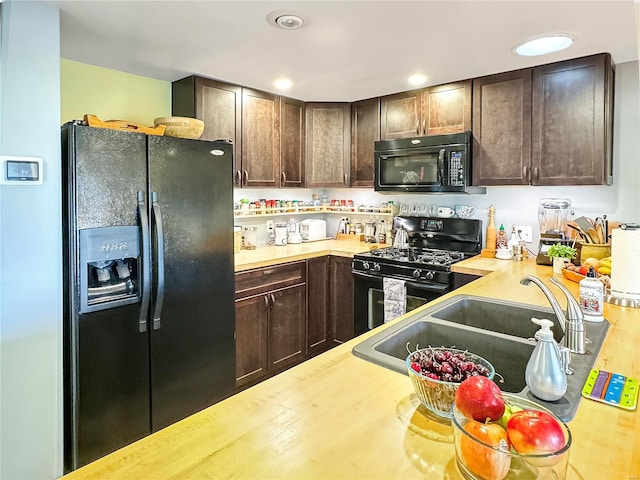 kitchen with dark brown cabinetry, sink, wood-type flooring, and black appliances