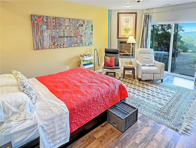 bedroom with wood-type flooring and access to exterior