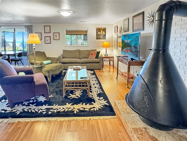 living room featuring hardwood / wood-style floors, a healthy amount of sunlight, and a wood stove