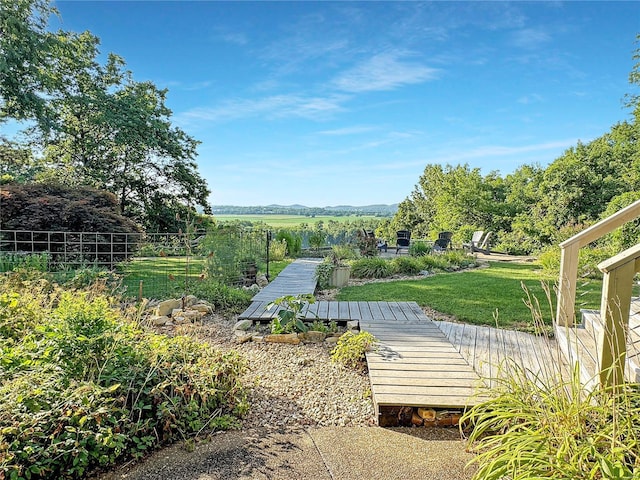 surrounding community featuring a rural view, a lawn, and a deck