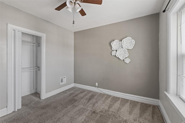 unfurnished bedroom featuring ceiling fan, a closet, and carpet