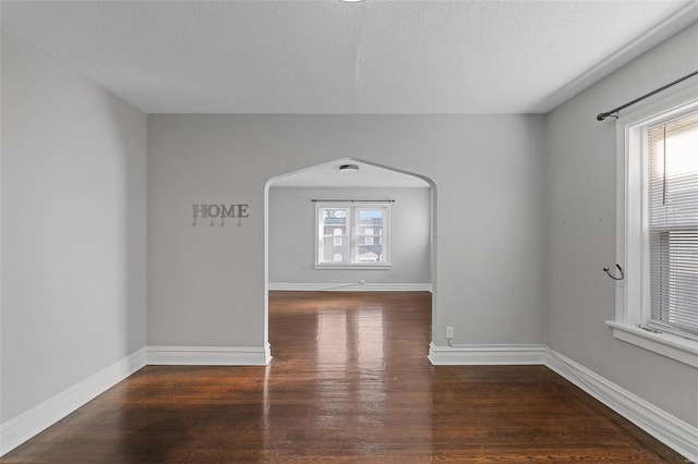 unfurnished room with dark hardwood / wood-style floors and a textured ceiling