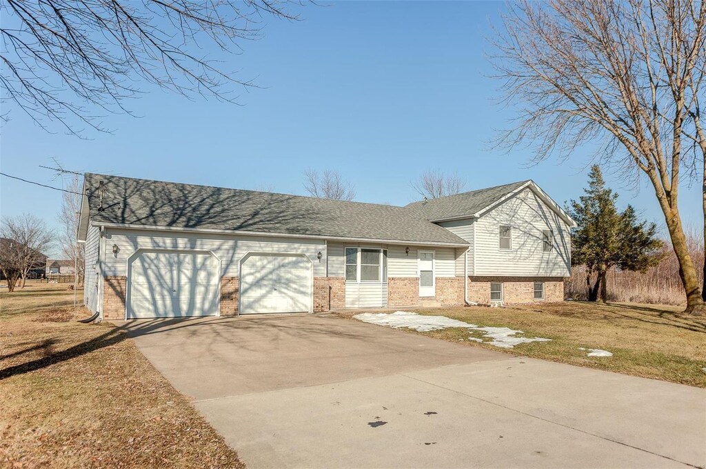 tri-level home featuring a garage and a front yard