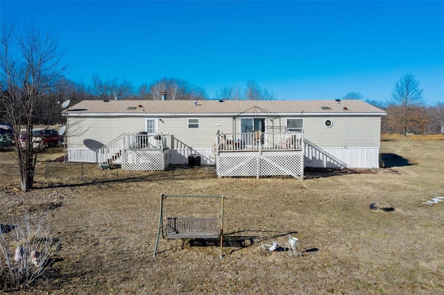 rear view of house with central AC unit, a lawn, and a deck