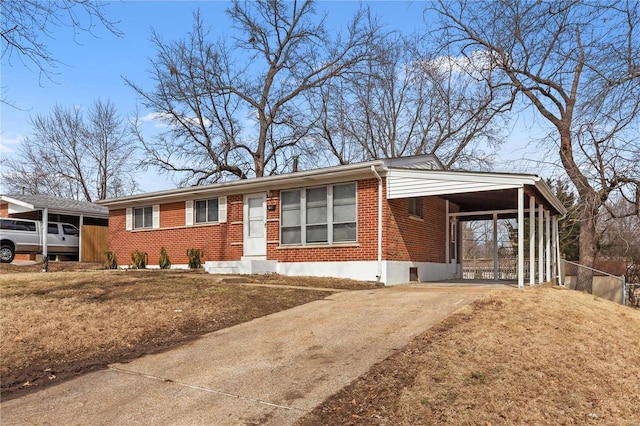 ranch-style house with driveway, entry steps, brick siding, an attached carport, and a front yard