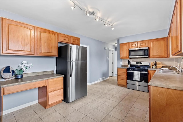 kitchen featuring stainless steel appliances, visible vents, backsplash, light tile patterned flooring, and a sink