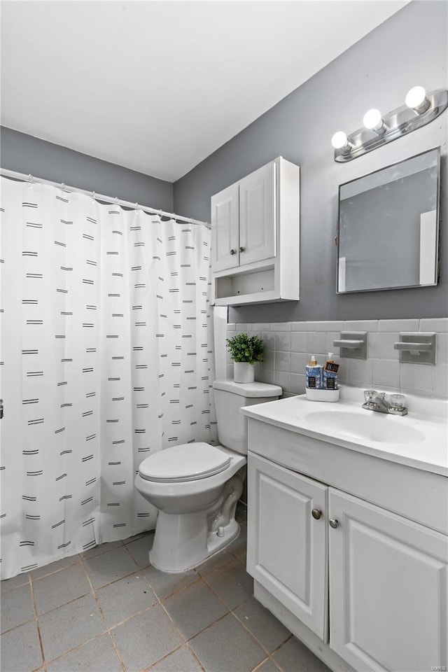 full bathroom with tile walls, a shower with shower curtain, vanity, and toilet