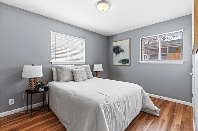 bedroom with dark wood finished floors and baseboards