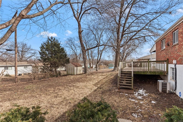 view of yard with a deck, an outbuilding, cooling unit, a storage shed, and stairs