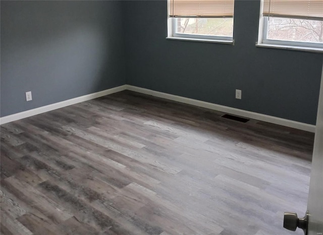 spare room featuring wood-type flooring and a wealth of natural light