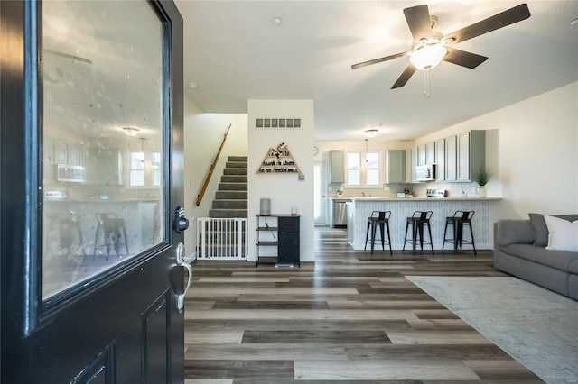 living room with dark wood-type flooring and ceiling fan