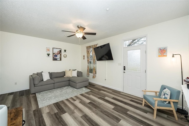 living room with ceiling fan, dark hardwood / wood-style floors, and a textured ceiling