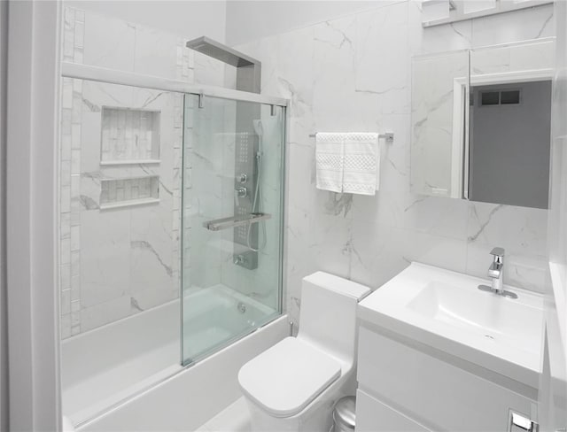 full bathroom featuring combined bath / shower with glass door, tile walls, decorative backsplash, vanity, and toilet