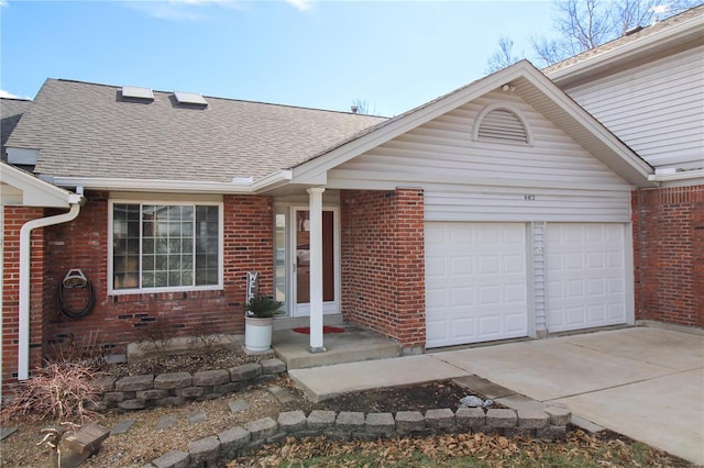 single story home featuring a garage, roof with shingles, concrete driveway, and brick siding