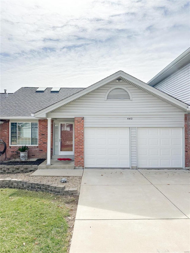 single story home with concrete driveway, a garage, brick siding, and roof with shingles