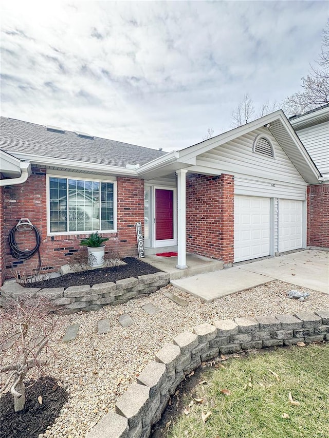 ranch-style home with a garage, brick siding, driveway, and a shingled roof