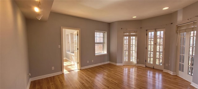 spare room featuring french doors and light hardwood / wood-style floors