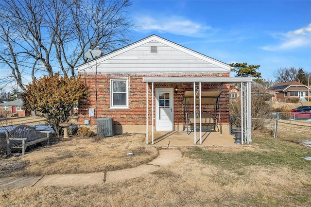 view of front of property featuring central AC unit, a patio area, and a front lawn