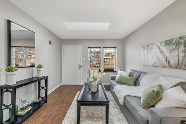 living room with dark hardwood / wood-style flooring and vaulted ceiling with skylight