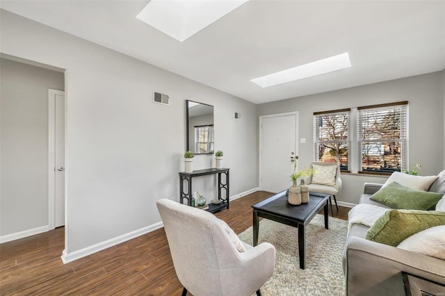 living room featuring dark hardwood / wood-style floors, a wealth of natural light, and a skylight