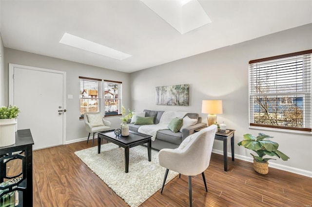 living room with dark wood-type flooring and a skylight