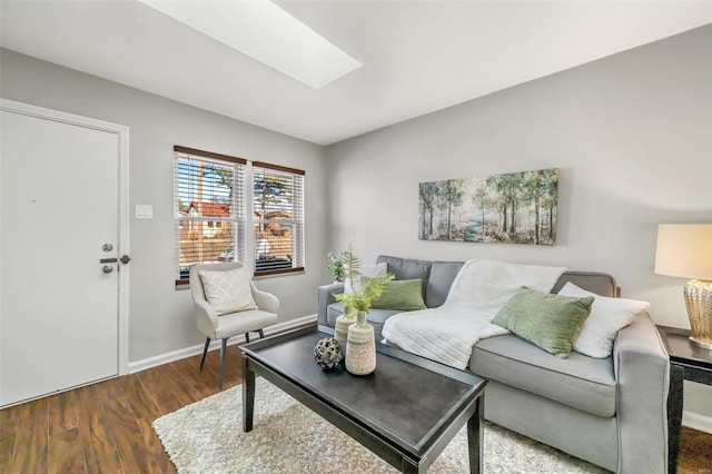 living room with dark hardwood / wood-style floors and a skylight