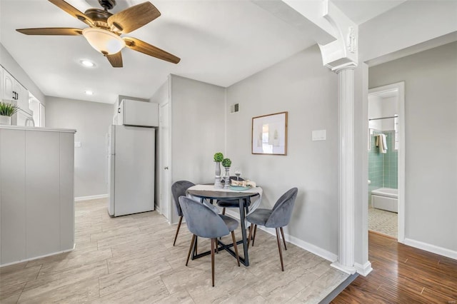 dining space featuring ceiling fan, decorative columns, and light hardwood / wood-style flooring