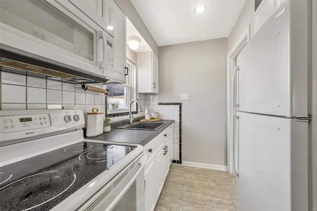 kitchen featuring backsplash, white appliances, sink, and white cabinets