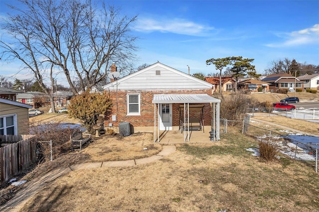 rear view of house with a patio, cooling unit, and a lawn