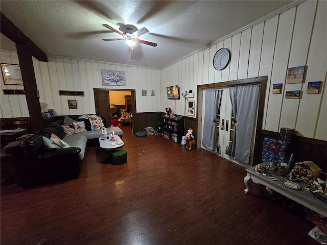 living room with hardwood / wood-style flooring, a textured ceiling, and ceiling fan