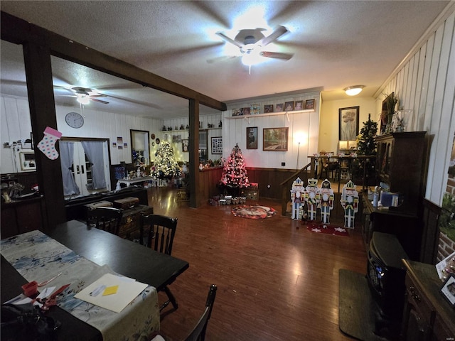 dining area with ceiling fan, wood-type flooring, beam ceiling, and a textured ceiling