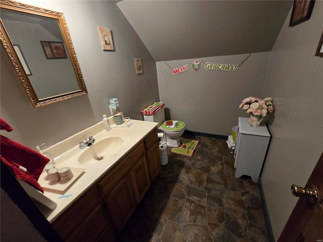 bathroom with vanity, lofted ceiling, and toilet