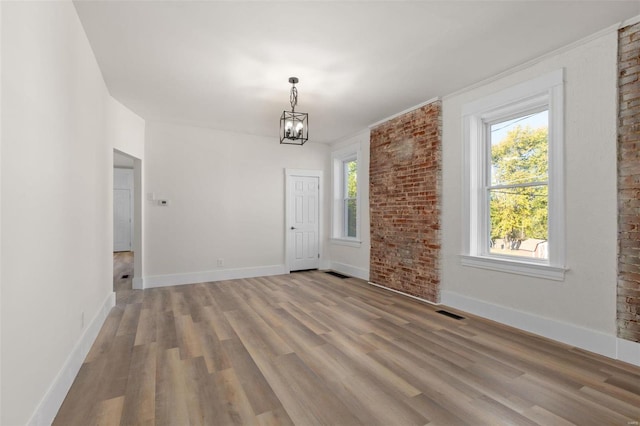 unfurnished dining area featuring hardwood / wood-style floors and a notable chandelier