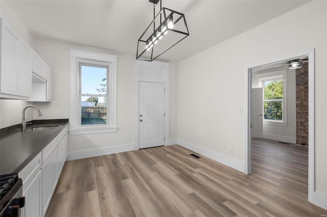 unfurnished dining area featuring sink and light hardwood / wood-style floors