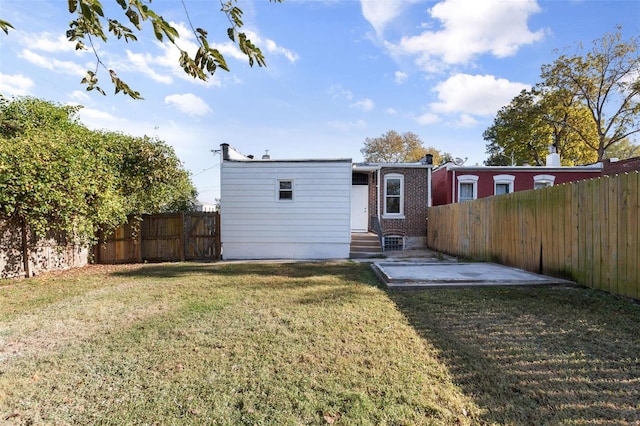 back of house with a yard and a patio area