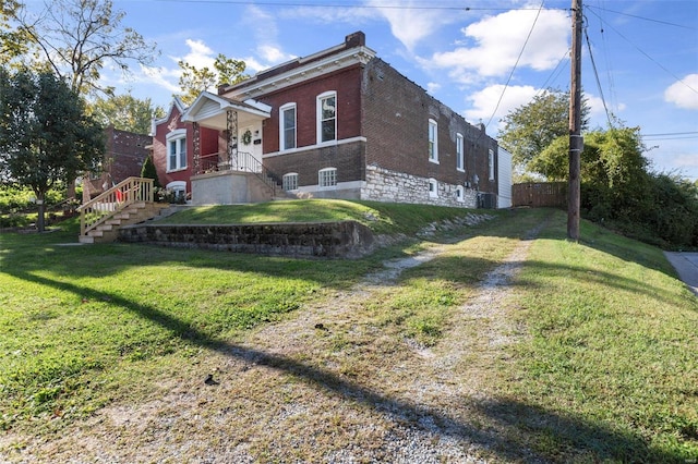 view of side of home with a yard