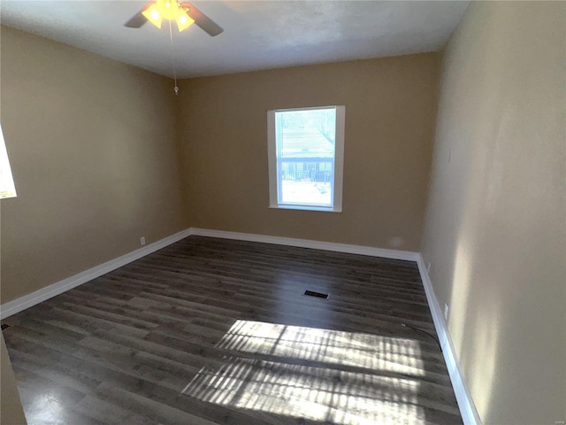 empty room with dark wood-type flooring and ceiling fan