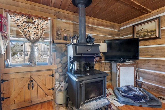 interior space featuring wood walls, wooden ceiling, hardwood / wood-style floors, and a wood stove