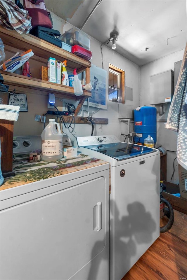 washroom with hardwood / wood-style flooring and washing machine and dryer