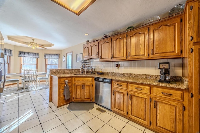 kitchen featuring light tile patterned floors, dishwasher, ceiling fan, tasteful backsplash, and kitchen peninsula