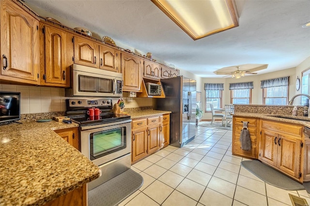 kitchen with light tile patterned flooring, sink, backsplash, ceiling fan, and stainless steel appliances