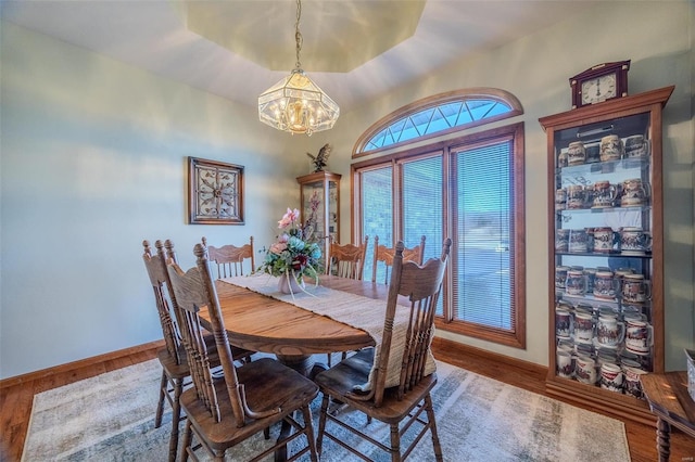 dining space featuring hardwood / wood-style flooring and a chandelier