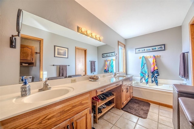 bathroom featuring vanity, tile patterned floors, a tub, and toilet