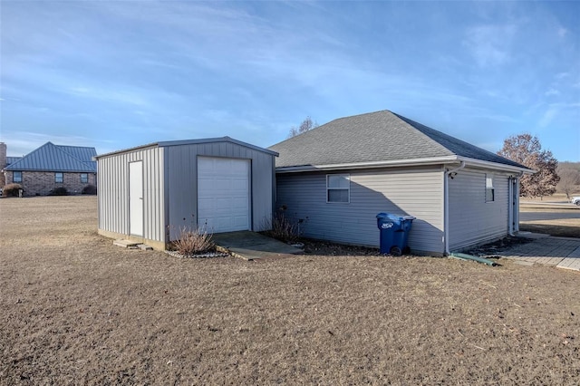 rear view of house featuring an outbuilding and a garage