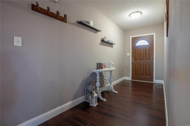 foyer featuring dark hardwood / wood-style floors and a textured ceiling