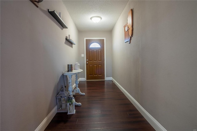 doorway to outside with dark hardwood / wood-style floors and a textured ceiling