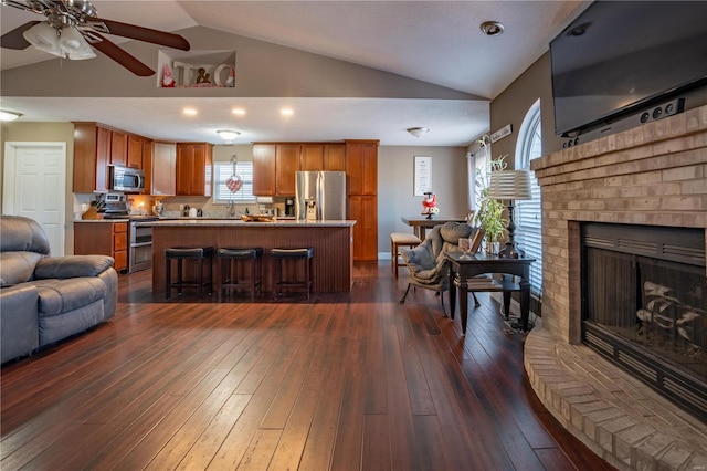 living room with ceiling fan, lofted ceiling, dark hardwood / wood-style floors, and a fireplace