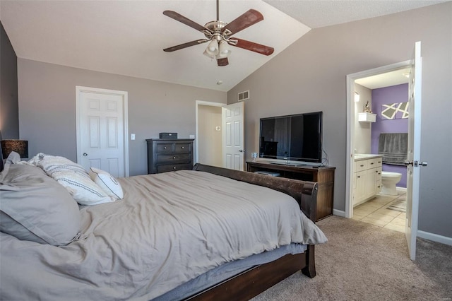 carpeted bedroom featuring ceiling fan, ensuite bathroom, and vaulted ceiling