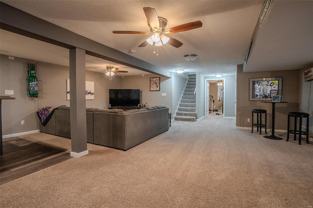 carpeted living room with ceiling fan and a textured ceiling