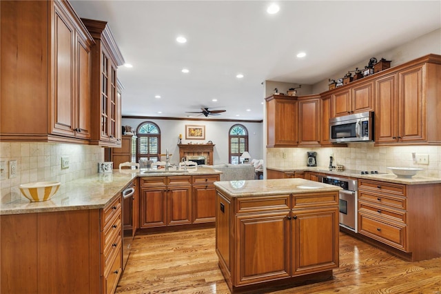 kitchen featuring a center island, stainless steel appliances, kitchen peninsula, and light hardwood / wood-style flooring